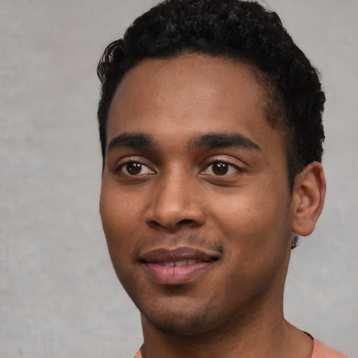 Joyful black young-adult male with short  black hair and brown eyes