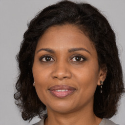 Joyful black adult female with medium  brown hair and brown eyes