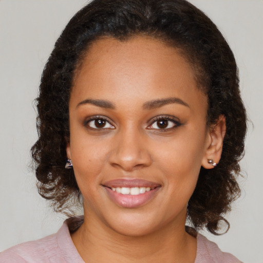 Joyful black young-adult female with medium  brown hair and brown eyes