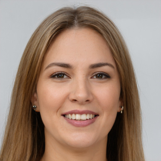 Joyful white young-adult female with long  brown hair and brown eyes