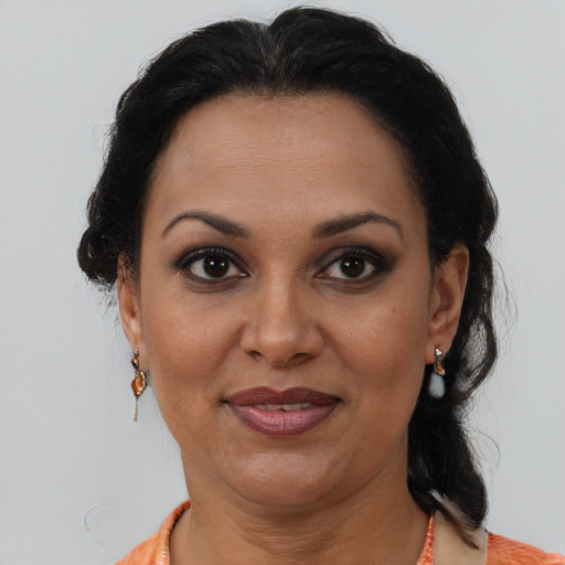 Joyful latino adult female with medium  brown hair and brown eyes