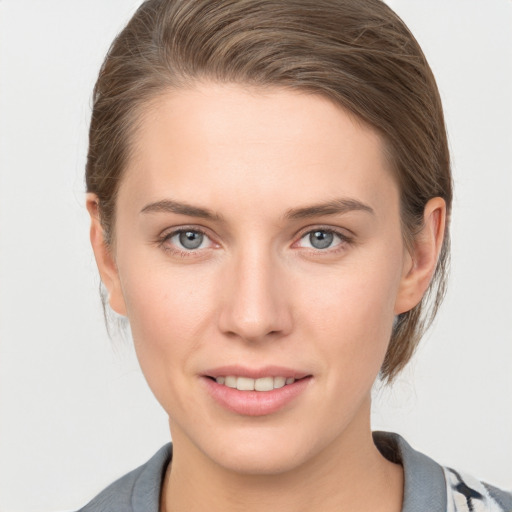 Joyful white young-adult female with medium  brown hair and grey eyes