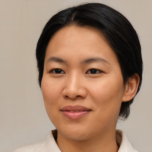 Joyful asian young-adult female with medium  brown hair and brown eyes
