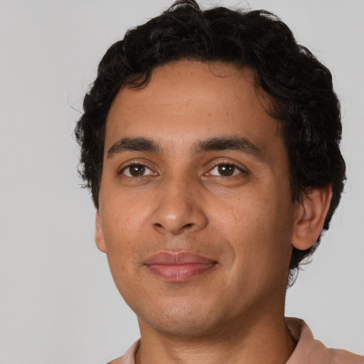 Joyful latino young-adult male with short  brown hair and brown eyes