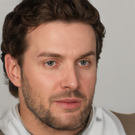 Joyful white young-adult male with short  brown hair and blue eyes