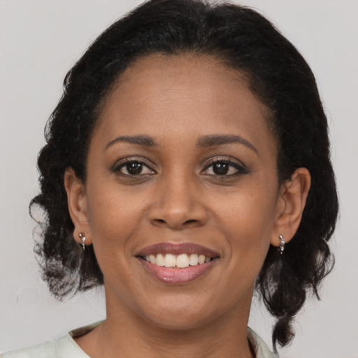 Joyful black young-adult female with medium  brown hair and brown eyes