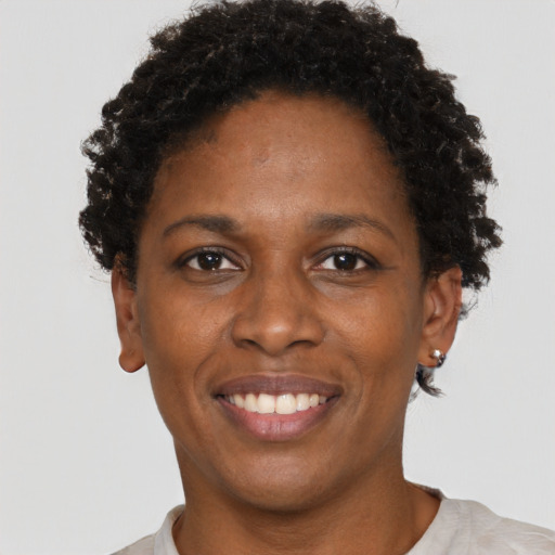Joyful black young-adult female with short  brown hair and brown eyes