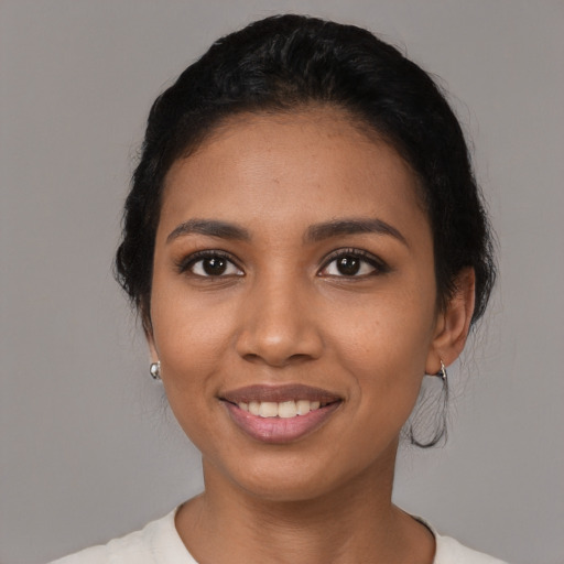 Joyful latino young-adult female with short  black hair and brown eyes