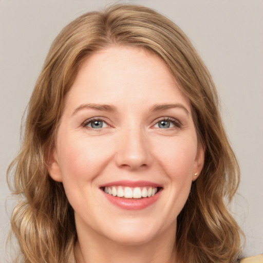 Joyful white young-adult female with medium  brown hair and green eyes