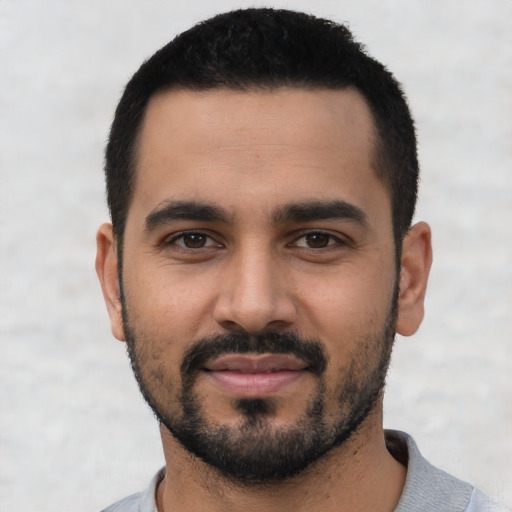 Joyful latino young-adult male with short  black hair and brown eyes