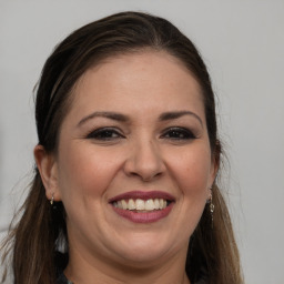 Joyful white adult female with long  brown hair and brown eyes