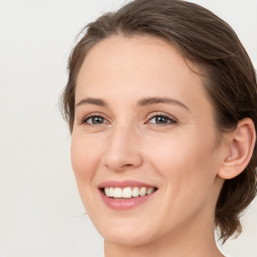 Joyful white young-adult female with medium  brown hair and green eyes