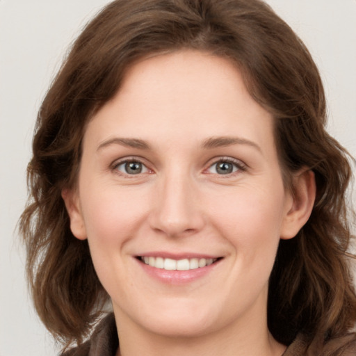 Joyful white young-adult female with medium  brown hair and grey eyes