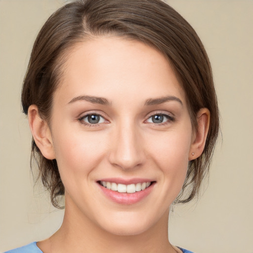 Joyful white young-adult female with medium  brown hair and grey eyes