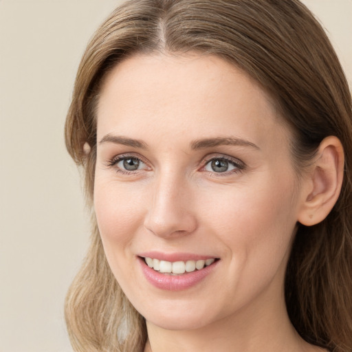 Joyful white young-adult female with long  brown hair and grey eyes