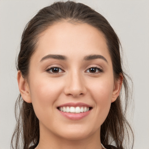 Joyful white young-adult female with long  brown hair and brown eyes