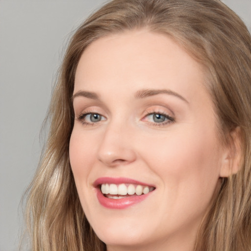 Joyful white young-adult female with long  brown hair and grey eyes