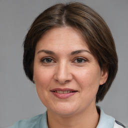 Joyful white adult female with medium  brown hair and grey eyes