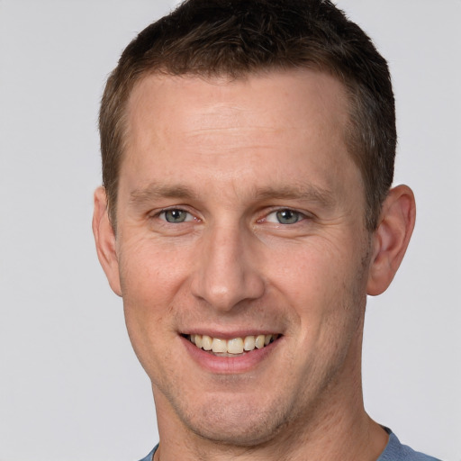 Joyful white adult male with short  brown hair and grey eyes