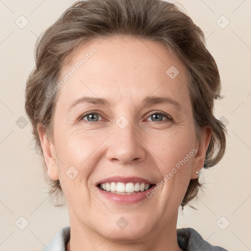 Joyful white adult female with medium  brown hair and grey eyes