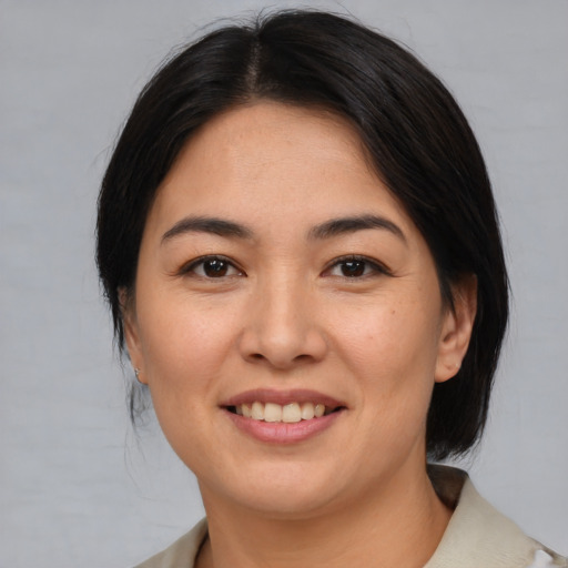 Joyful asian young-adult female with medium  brown hair and brown eyes