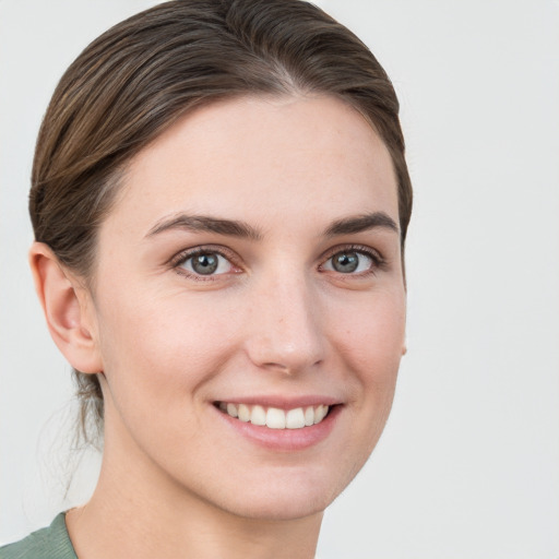 Joyful white young-adult female with short  brown hair and grey eyes