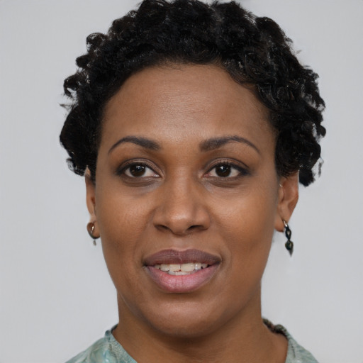 Joyful black young-adult female with short  black hair and brown eyes