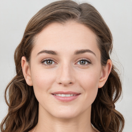 Joyful white young-adult female with long  brown hair and blue eyes