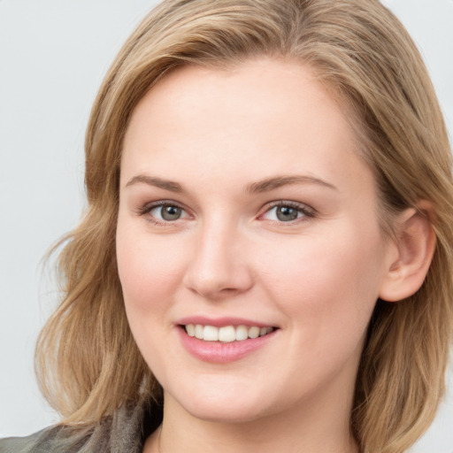 Joyful white young-adult female with long  brown hair and blue eyes