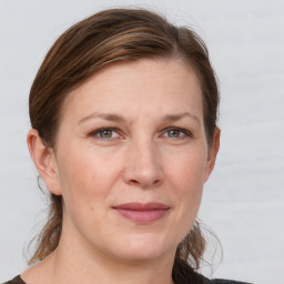 Joyful white adult female with medium  brown hair and grey eyes