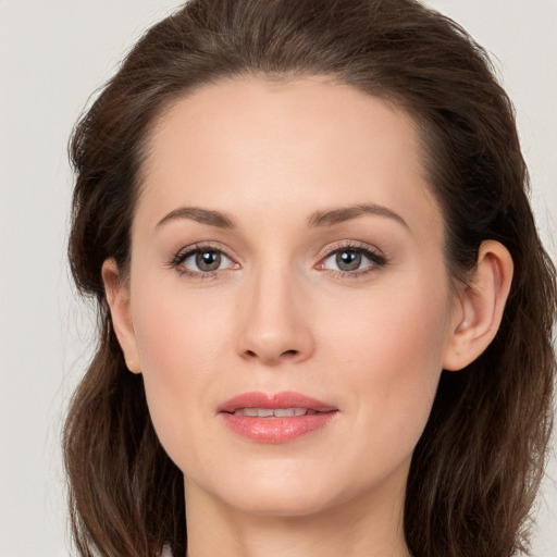 Joyful white young-adult female with long  brown hair and grey eyes