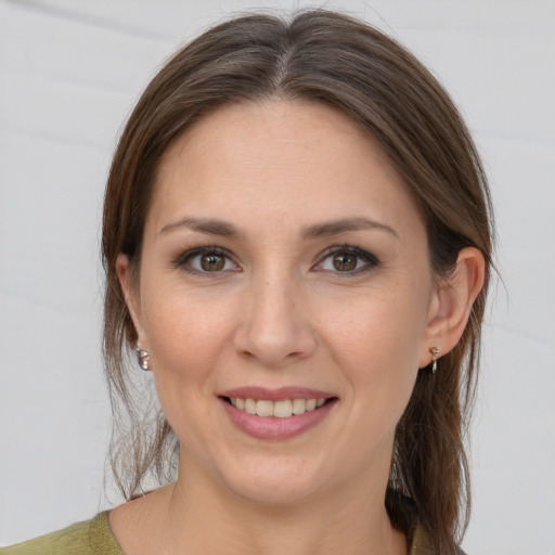 Joyful white young-adult female with medium  brown hair and grey eyes