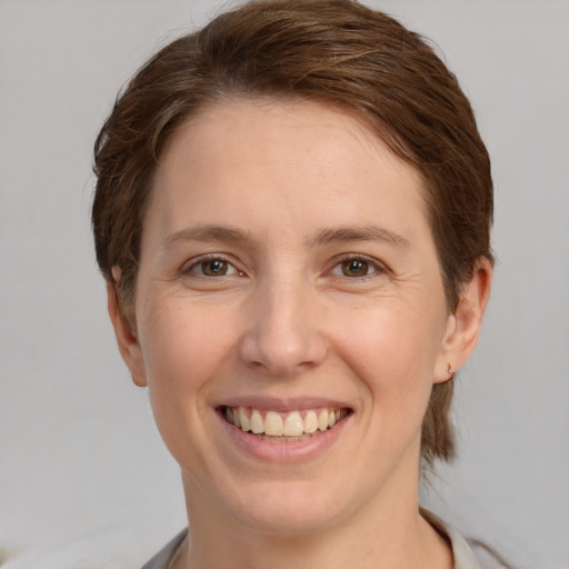 Joyful white young-adult female with short  brown hair and grey eyes