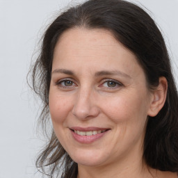 Joyful white adult female with long  brown hair and brown eyes