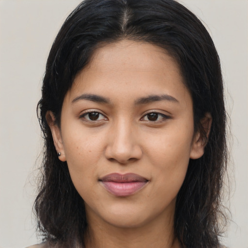 Joyful latino young-adult female with long  brown hair and brown eyes