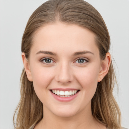 Joyful white young-adult female with long  brown hair and grey eyes