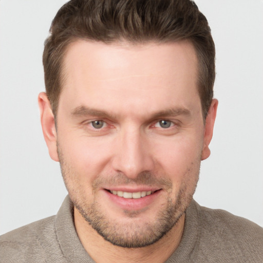 Joyful white young-adult male with short  brown hair and grey eyes