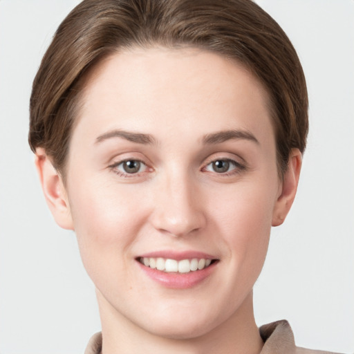 Joyful white young-adult female with short  brown hair and grey eyes