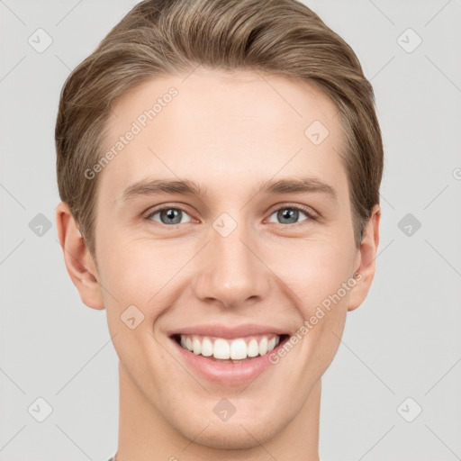 Joyful white young-adult male with short  brown hair and grey eyes