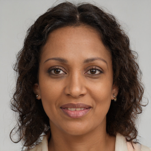 Joyful black adult female with long  brown hair and brown eyes