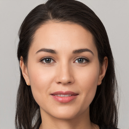 Joyful white young-adult female with long  brown hair and brown eyes