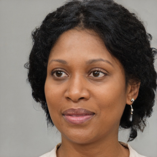 Joyful black adult female with medium  brown hair and brown eyes