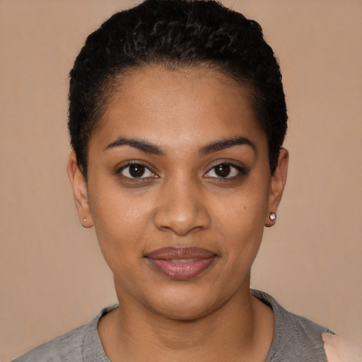 Joyful black young-adult female with short  black hair and brown eyes
