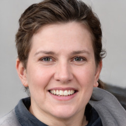 Joyful white young-adult female with medium  brown hair and blue eyes