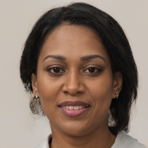 Joyful black adult female with medium  brown hair and brown eyes