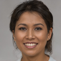 Joyful latino young-adult female with medium  brown hair and brown eyes