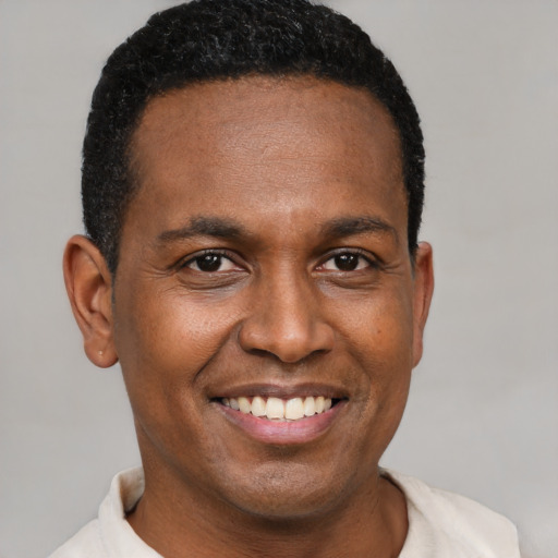 Joyful black young-adult male with short  brown hair and brown eyes
