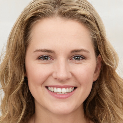 Joyful white young-adult female with long  brown hair and green eyes