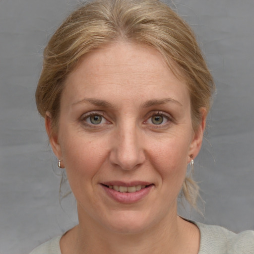 Joyful white adult female with medium  brown hair and blue eyes