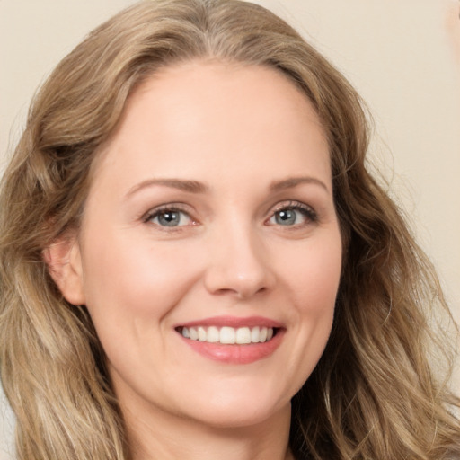 Joyful white young-adult female with long  brown hair and green eyes